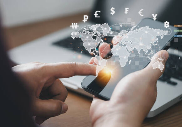 Man using mobile phone and laptop computer to money transfers and currency exchanges between countries of the world. online banking interbank payment concept.